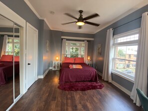 Relax in this serene bedroom with a large bed, bedside tables, and a ceiling fan.