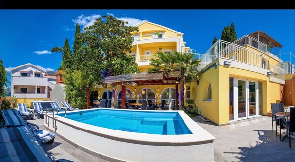 Ein Hotel mit Pool, Außenbereich und einem gelben Gebäude mit Balkonen.