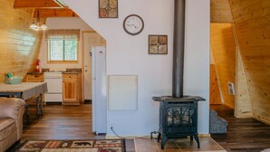 A cozy, wooden interior with a kitchen, a dining area, and a wood-burning stove. - Aspen Ridge Cabin WIFI, 2bed+1Bath, 20mins to Yellowstone (Island Park)