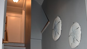 A staircase with white steps and wooden handrails, leading to a door at the top.