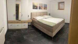 A bedroom with a bed, a wardrobe, and a small window.