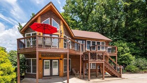 A two-story wooden house with a balcony and a staircase. - Lake View Chalet! Game Room! Hot Tub! (Silverpoint)