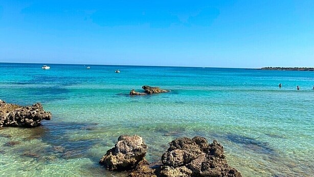 A clear blue sea with rocky formations in the foreground and a distant shoreline. - Villa Ale - Fontane Bianche  (Fontane Bianche)