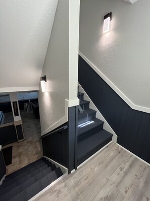Stairs lead to an upper level, featuring a door and a light fixture.