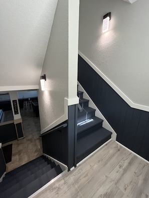 Stairs lead to an upper level, featuring a door and a light fixture.