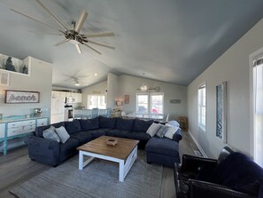 Relax in this inviting living space with a sofa, dining table, and kitchen area.