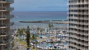 A marina with numerous boats docked, surrounded by tall buildings with balconies overlooking the water. - Monthly Discovery Bay 1713 Ocean/City Views 1 Bd 1Ba (Honolulu)