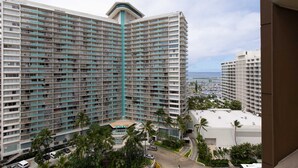 A high-rise hotel with multiple balconies, a pool area, and a view of the ocean. - Monthly Discovery Bay 1713 Ocean/City Views 1 Bd 1Ba (Honolulu)
