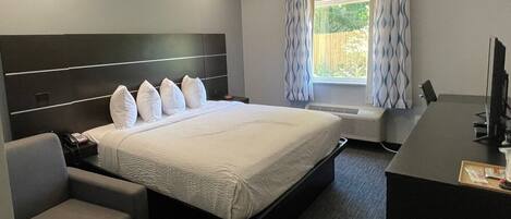 Habitación de hotel con una cama grande, un escritorio y una silla.