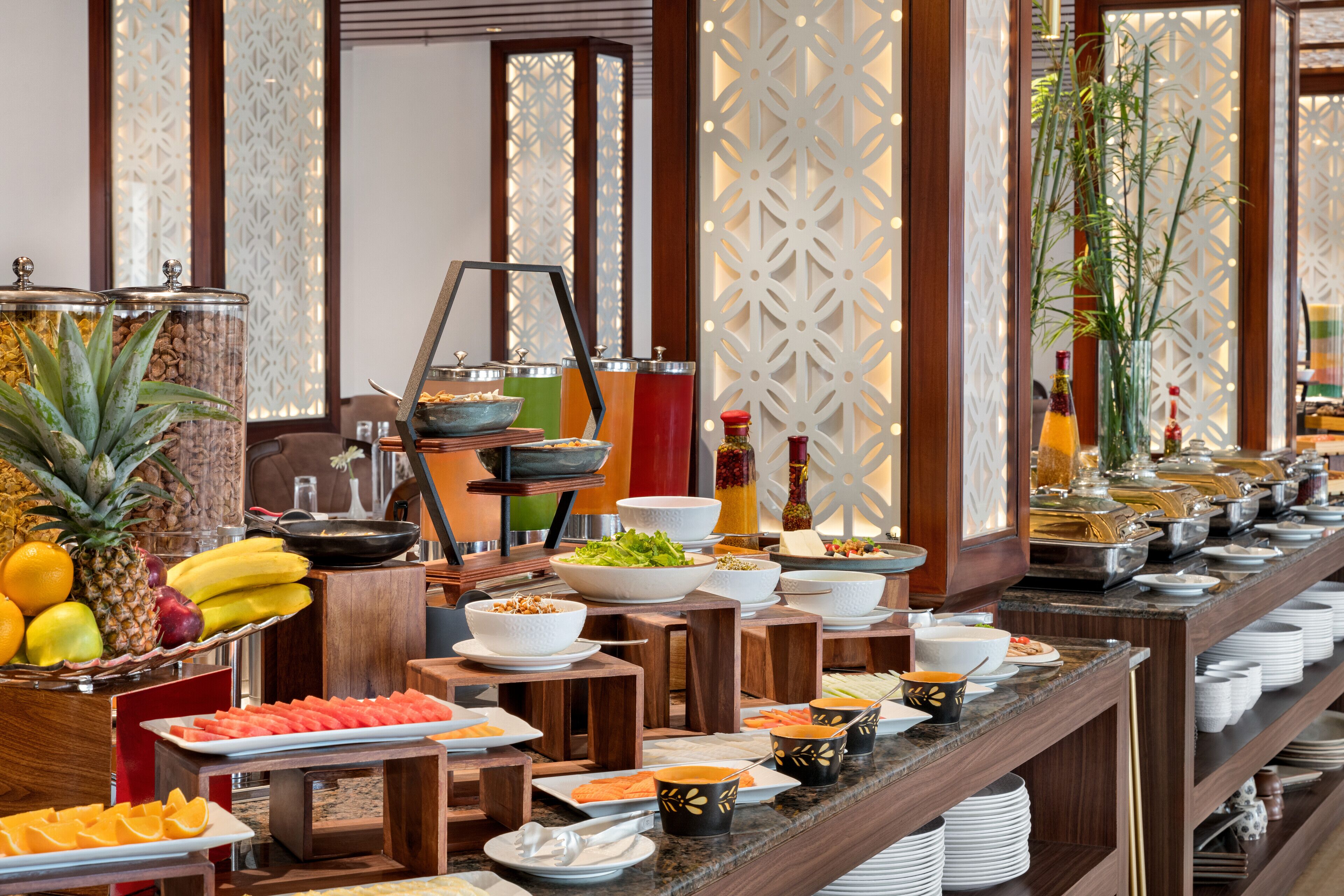 A buffet with various food items and a fruit display.