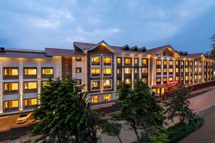 A multi-story hotel with a modern architectural design, featuring a series of balconies and large windows.