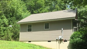 A two-story house with a sloped roof, a small front porch, and a garage.