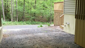 A covered outdoor area with a gravel path leading to a wooden deck.