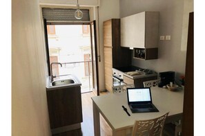 Compact kitchen with modern appliances, stove, and sink, perfect for a productive workspace.