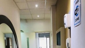 Une chambre d’hôtel avec un plancher en bois, un grand miroir, une télévision et un panneau indiquant une zone Wi-Fi gratuite.