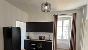 Eine kleine Küche mit Mikrowelle, Toaster und Waschmaschine.