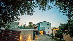 A modern two-story house with a stone facade, a balcony, and a paved driveway. - Villa Vida (Zmijavci)