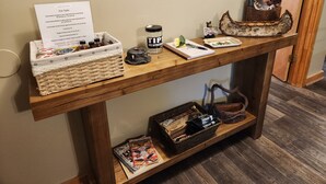 A wooden table with a sign, jars, a book, and a decorative item.