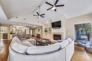 Relax in this spacious living area with a large L-shaped sofa, flat-screen TV, and dining area with a bar.