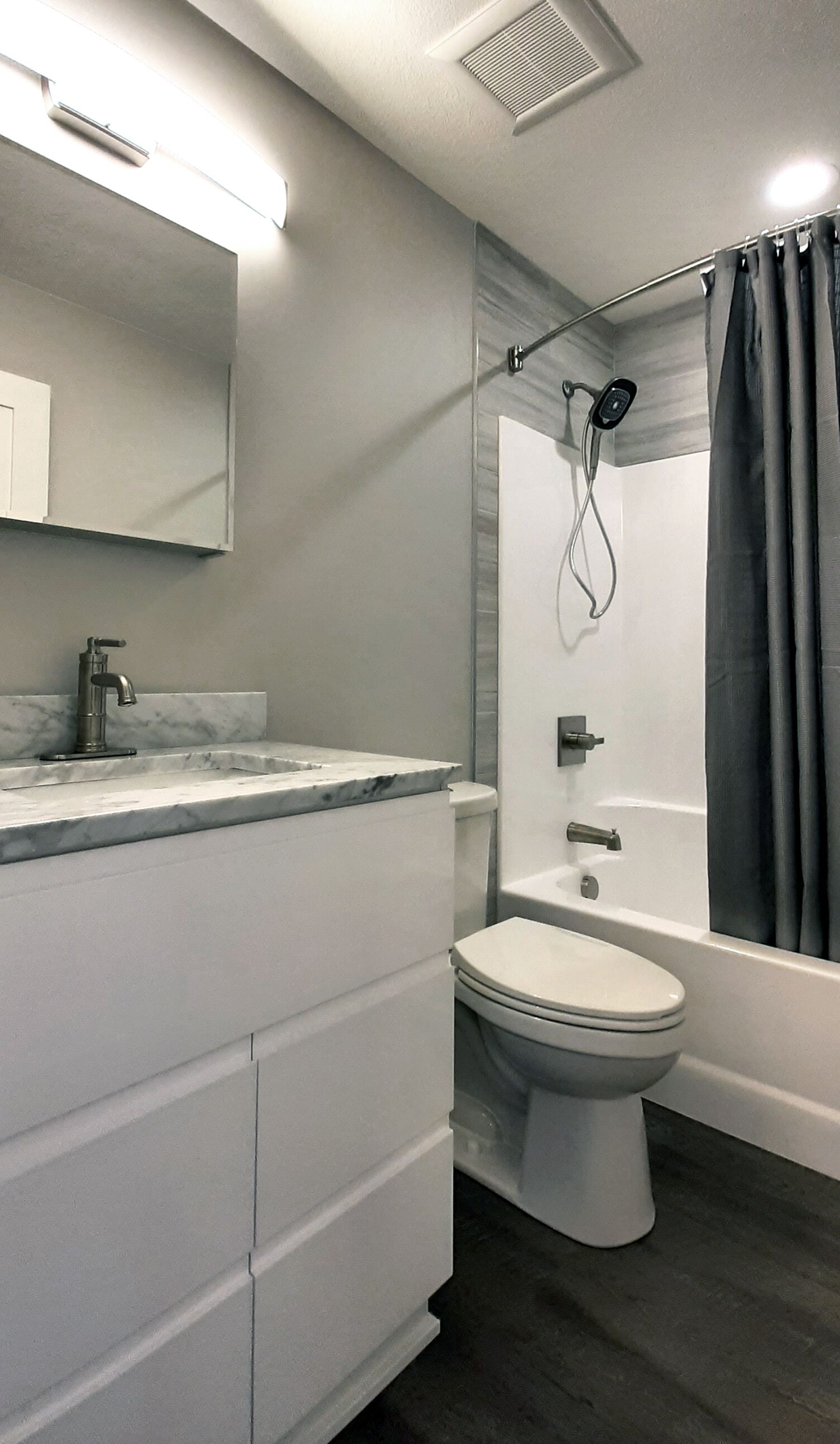Une salle de bain moderne avec un lavabo en marbre, des toilettes et une baignoire.