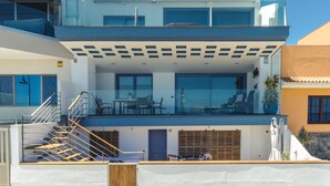 Um edifício moderno de vários andares com varanda, área de estar externa e escadaria.