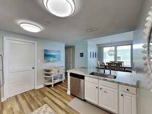 A modern kitchen with white cabinets, a dishwasher, and a marble countertop. - Seychelles #301 | Luxury Condo, Great Views, Pool! (Panama City Beach)