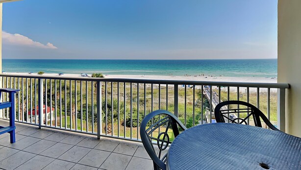 Un balcon avec vue sur la plage et l’océan.