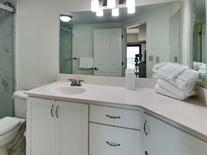 A bathroom with a white sink, mirror, and cabinet with drawers.