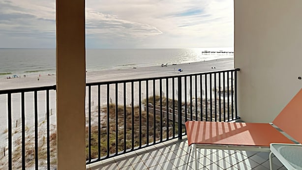 En balkon med udsigt til stranden og havet.