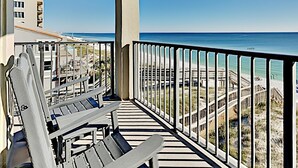 A balcony with a view of the beach and ocean.