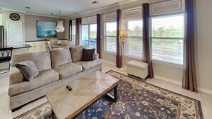 A living room with a sofa, coffee table, and a rug. - Beach Condo, Lake Views! (Orange Beach)