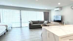 A modern hotel room with a bed, a sofa, a TV, and a marble countertop. - New Aloha Waikiki Ilikai Hotel Condo Free Parking (Honolulu)