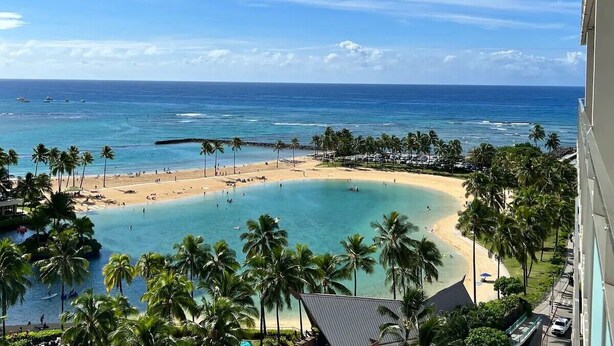A beach resort with a clear view of the ocean, palm trees, and a sandy beach. - New Aloha Waikiki Ilikai Hotel Condo Free Parking (Honolulu)