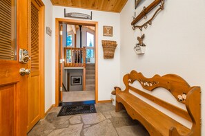 Enter a warm and inviting space with a traditional door, bench, and stone floor.