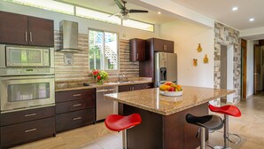 Una cocina moderna con armarios de madera oscura, electrodomésticos de acero inoxidable y encimera de granito.