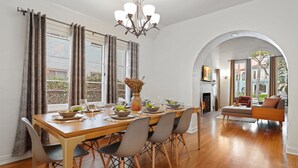 A dining area with a wooden table, grey chairs, and a vase with flowers. - LOVELY RESTORED VILLA NEAR BEVERLY HILLS (Los Angeles)