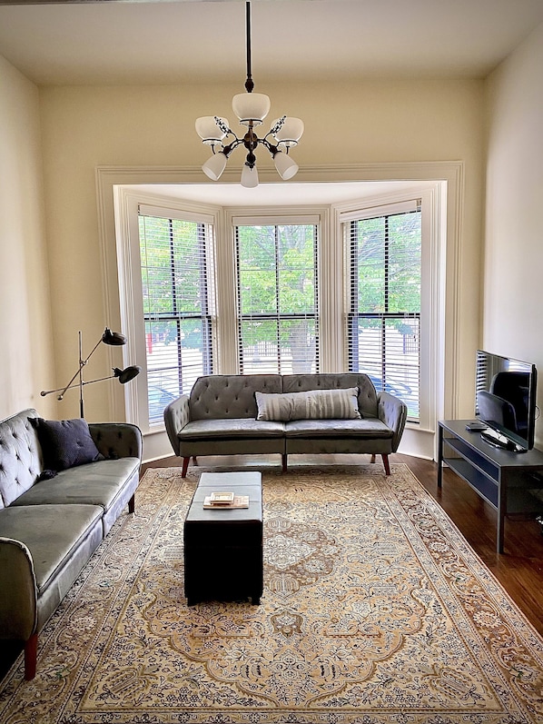 A living room with a sofa, coffee table, and a television on a stand.
