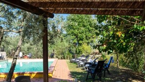 Uma área de refeições ao ar livre com piscina e cadeiras de varanda.