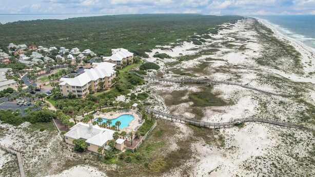An aerial view of a coastal resort with a large building, a swimming pool, and a beach. - PERFECT FORT MORGAN GETAWAY, ROOM FOR THE WHOLE FAMILY TO ENJOY! (Gulf Shores)