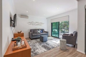 A modern living room with a sofa, armchair, and a coffee table.
