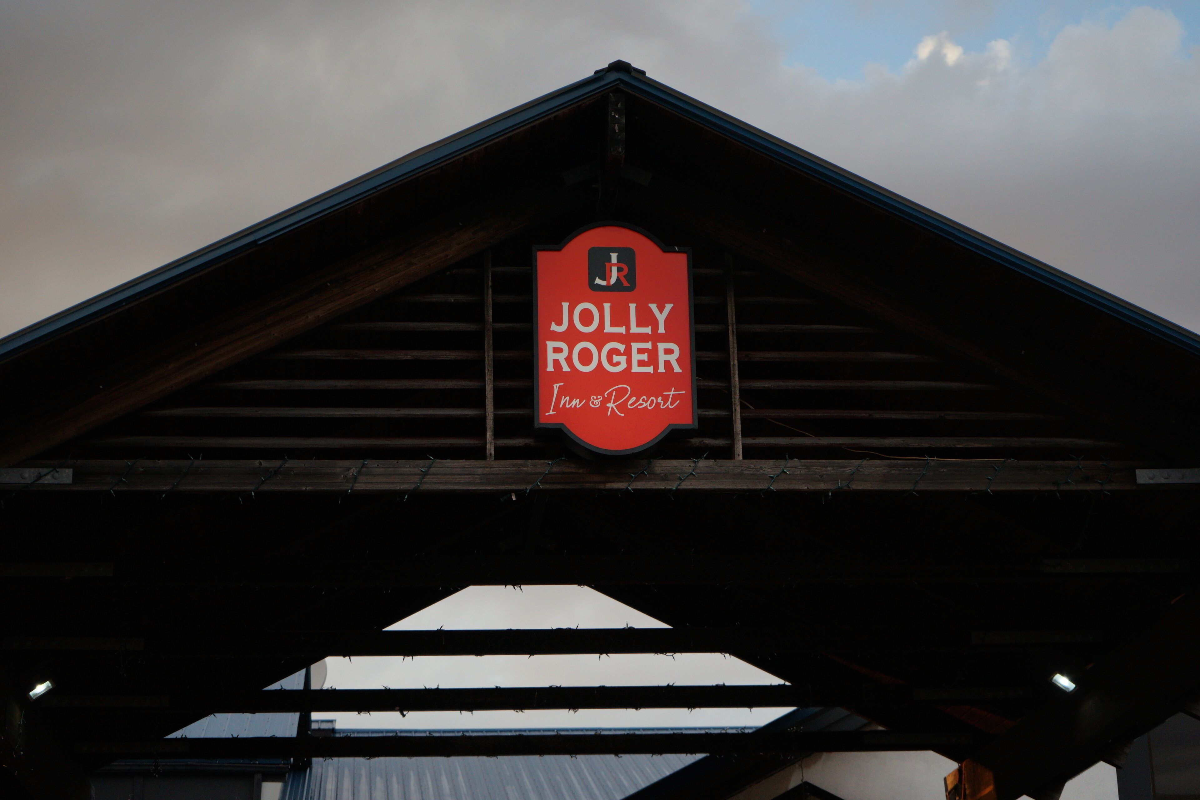 Une enseigne pour « Jolly Roger Inn & Resort », avec une structure de toit triangulaire.