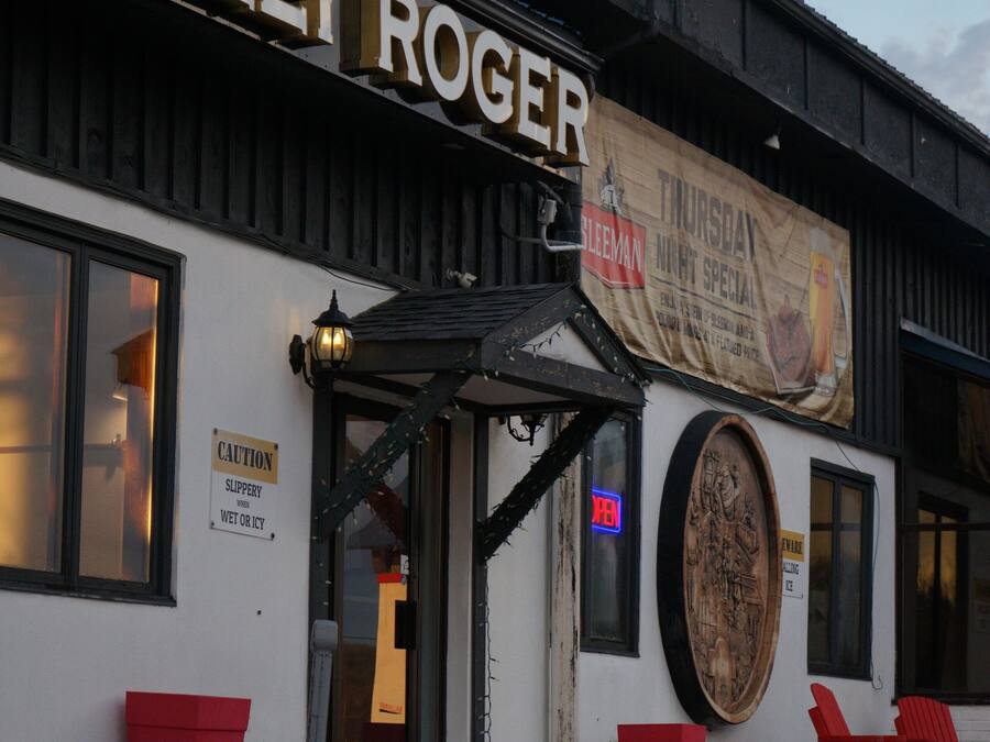 A building with a sign reading "JOLLY ROGER" and a banner advertising a Thursday night special.