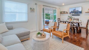 A cozy living room with a sofa, armchairs, a coffee table, and a dining area with a table and chairs. - Walk to Disney + Brand New Pool and Rockslide + Game Room + Pet Friendly (Anaheim)