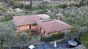 Propiedad residencial con una casa grande con techo de tejas, piscina y área cercada.