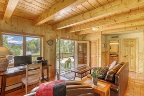 L’intérieur d’un chalet en bois comprend un coin repas, un canapé et offre une vue sur l’extérieur.