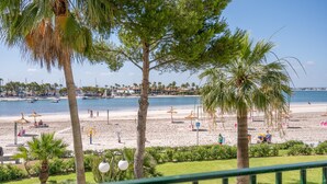 A beach with palm trees, a clear sky, and boats in the water. - Holiday Apartment "Carabela Greco 139" Near the Beach with Sea Views (Alcudia)