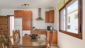 Cucina con mobili in legno, cappa in acciaio inossidabile, microonde e finestra vista edifici.