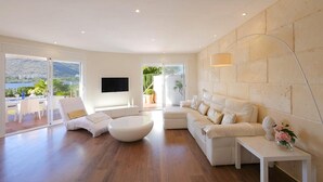 Una sala de estar moderna con un sofá, una mesa de centro y un televisor montado en la pared.