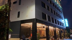 A multi-story hotel with a modern facade, large windows, and a well-lit entrance. - Weifeng Boutique Business Hotel (Pingtung)