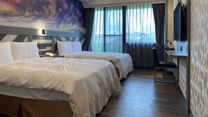 A hotel room with two beds, a desk, a chair, a TV, and a large window with curtains. - Weifeng Boutique Business Hotel (Pingtung)